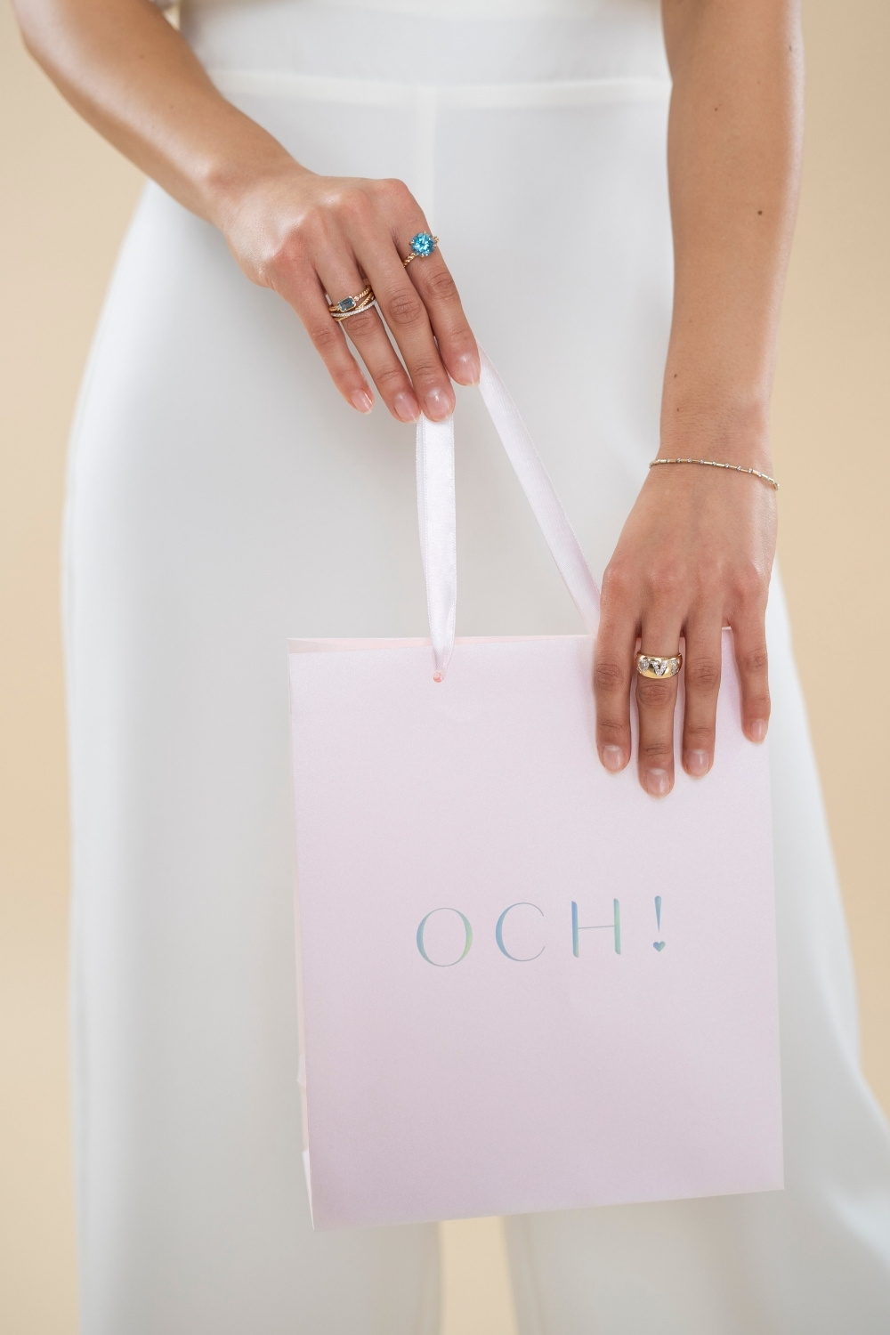 Kobieta z torebką prezentową OCH! i pierścionkami z topazami
