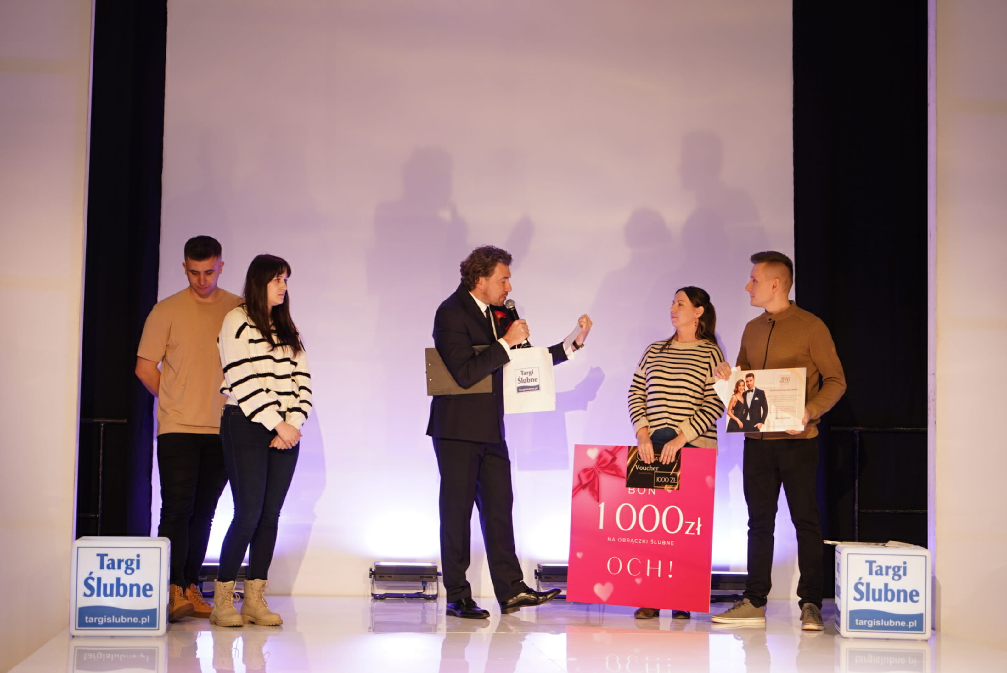 Prelegent na targach ślubnych wręcza parze bon jubilerski OCH!