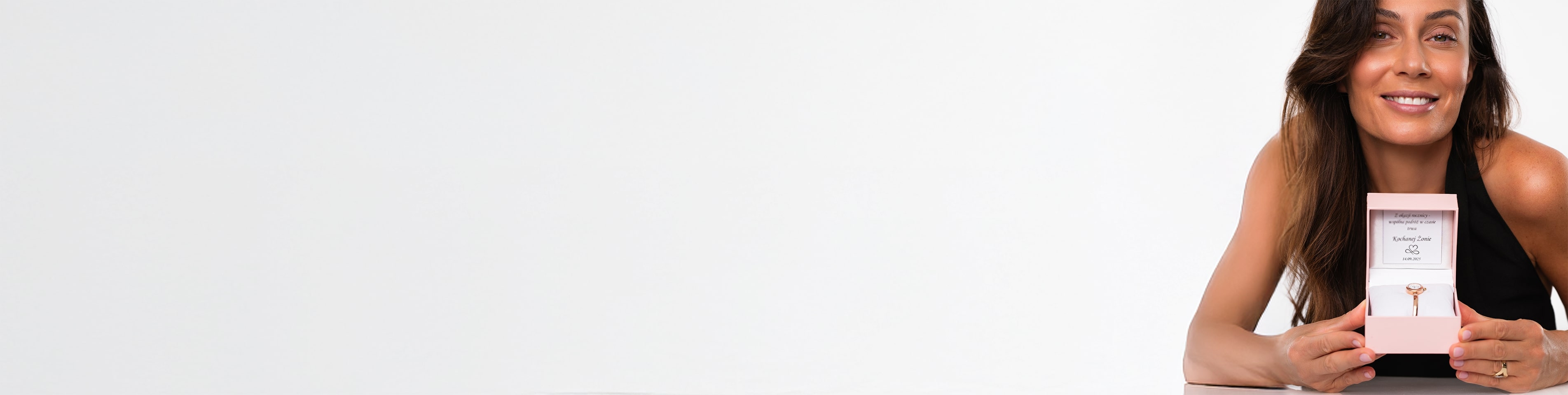 Kobieta i podełko z zegarkiem i tabliczką z grawerowanymi życzeniami