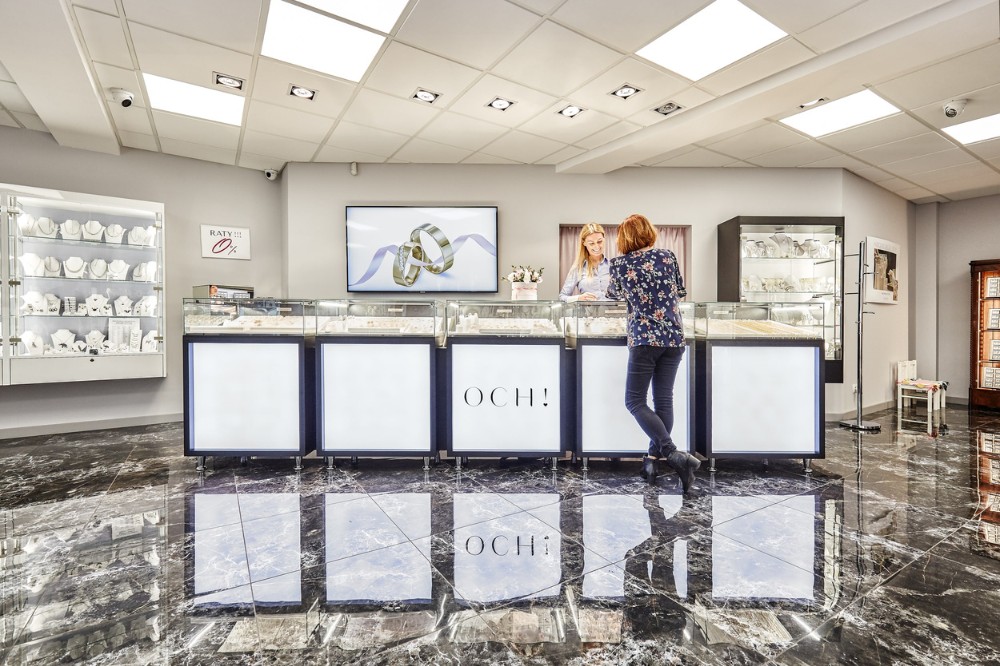 Ekspedientka doradza klientce w salonie jubilerskim dobór biżuterii