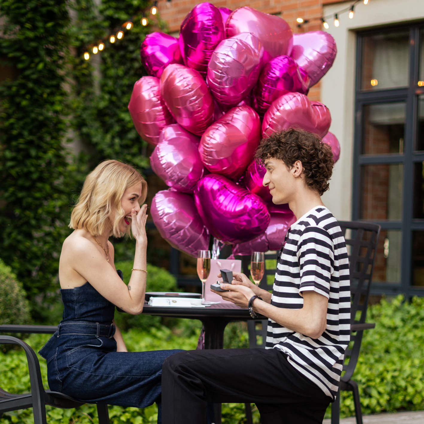Chłopak oświadcza się dziewczynie pierścionkiem zaręczynowym OCH! balony różowe
