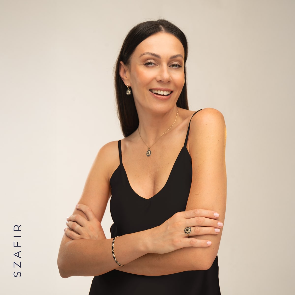 Kobieta w czarnej sukience ze złotą biżuterią z szafirami