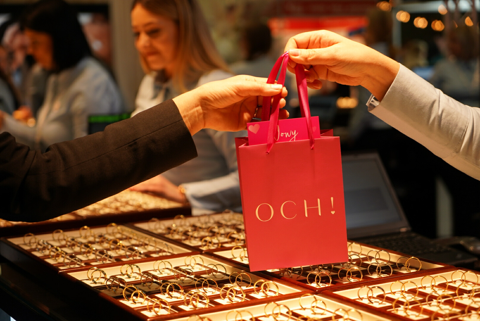 Kobieta dostaje torebke prezentową obrączek ślubnych OCH! na targach