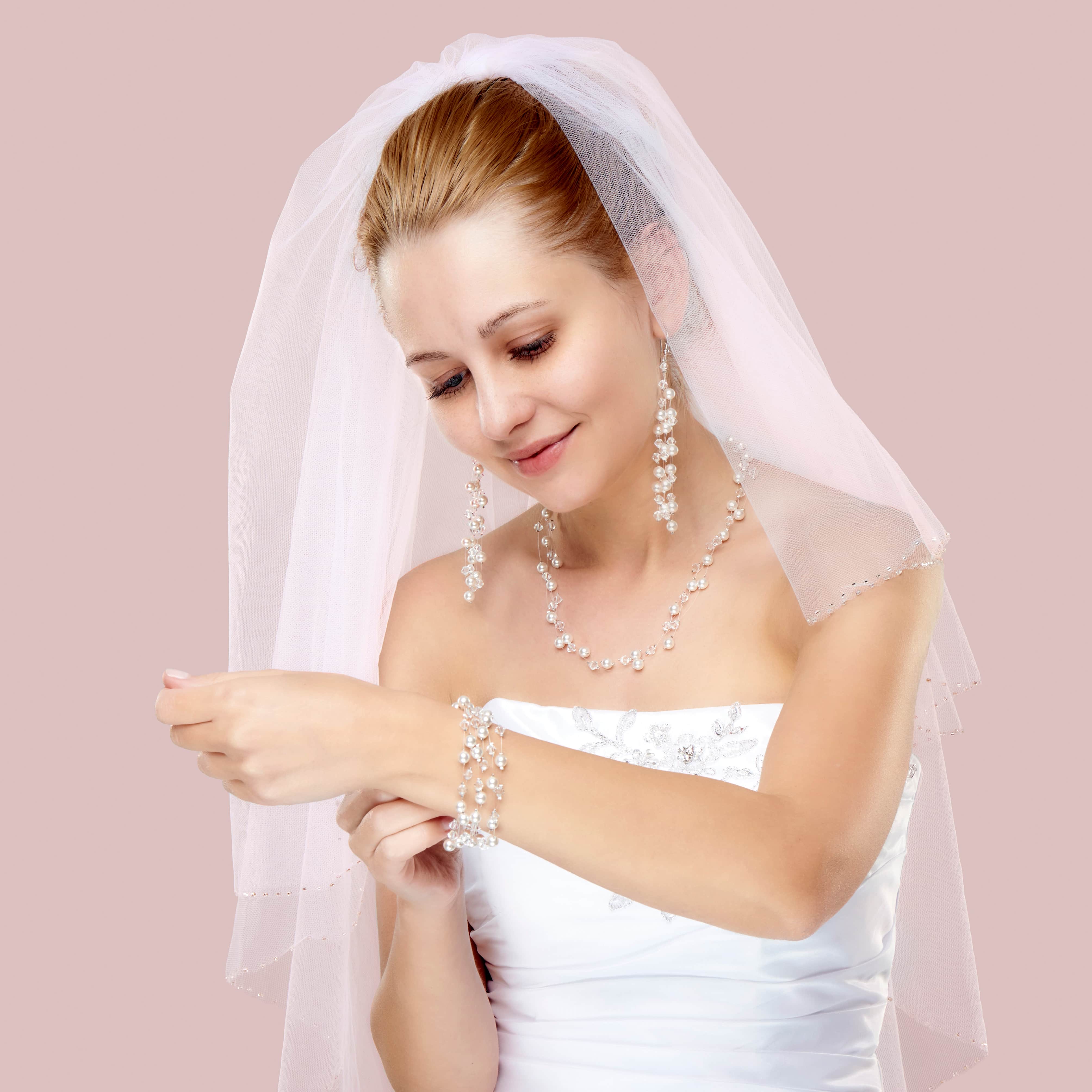 Panna młoda w sukni ślubnej i biżuterii z perłami